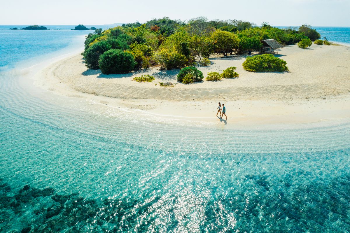 Tropical beach in Coron, Palawan with white sand and traditional outrigger boats